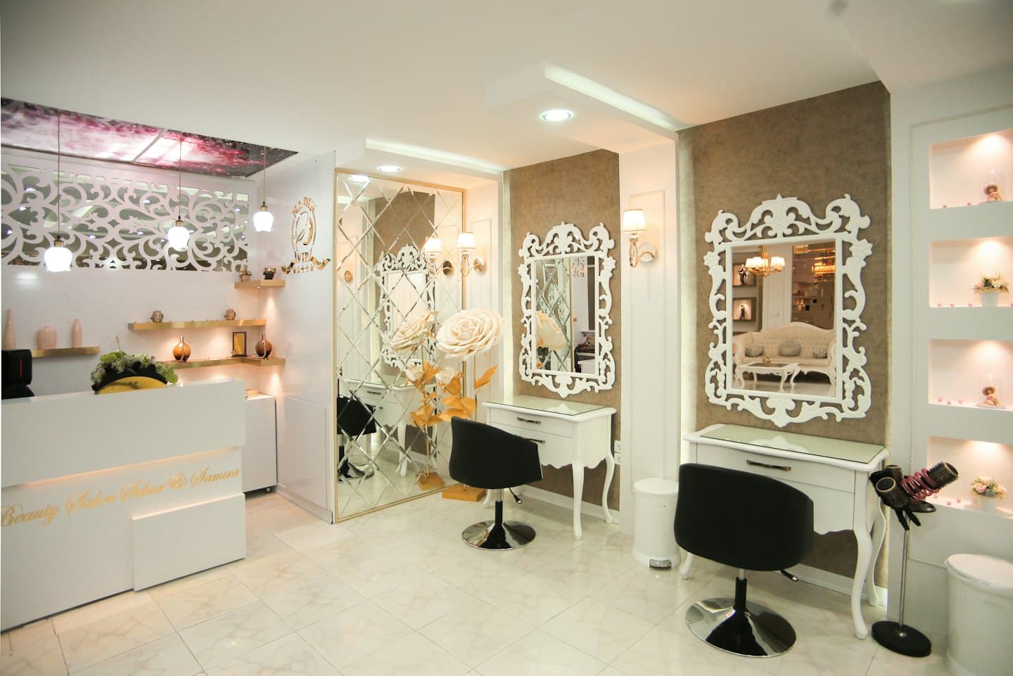 Leerer Luxus-Schönheitssalon mit weißem Empfangstresen und Friseurstühlen.