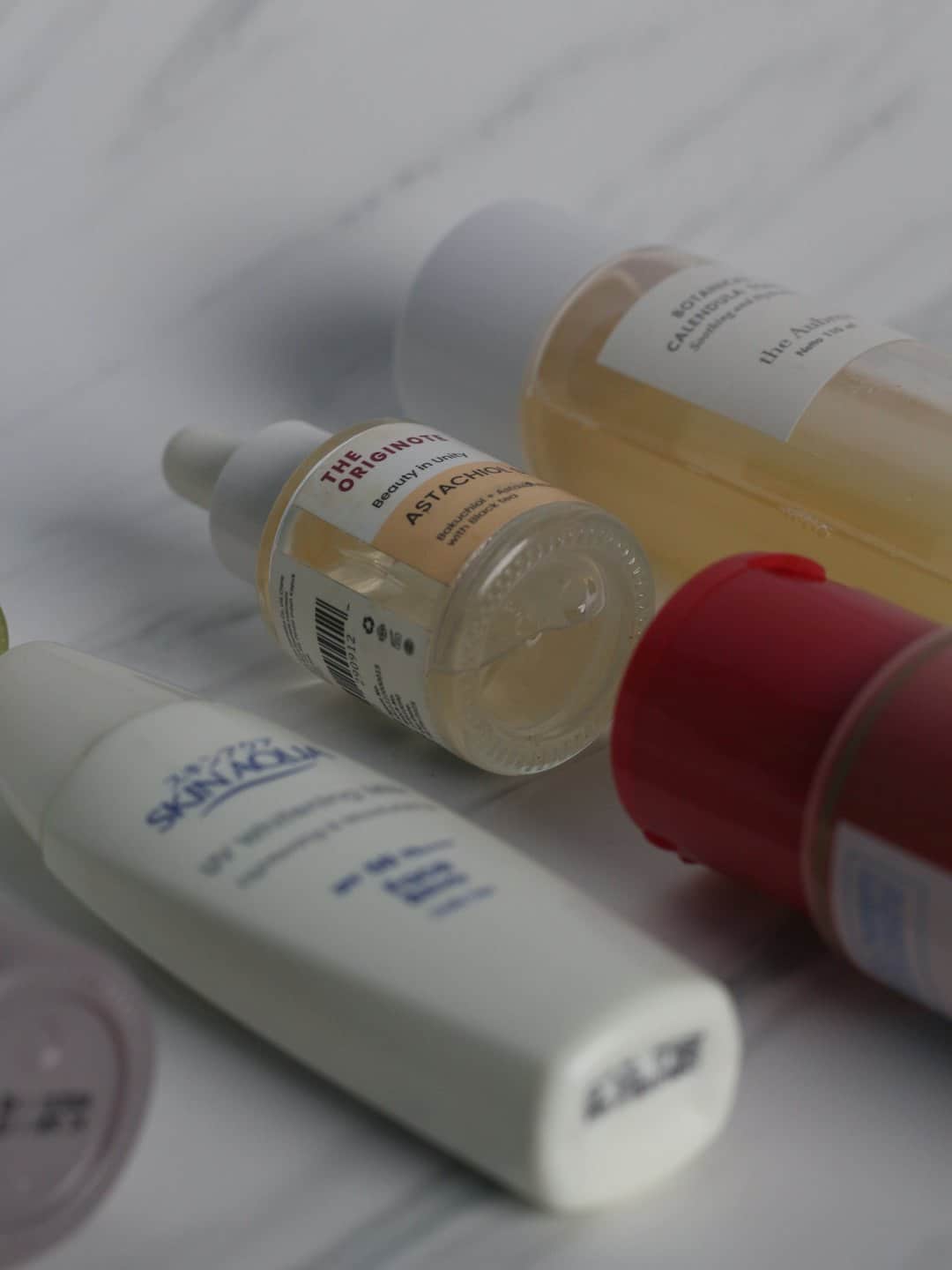 Pflegeproduktflaschen auf Marmor arrangiert.